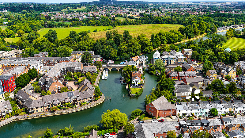 从空中俯瞰牛津，泰晤士河及周边住宅区，河岸边的船只和绿色的乡村景观，英格兰的旅行、历史传承与都市生活概念图片素材