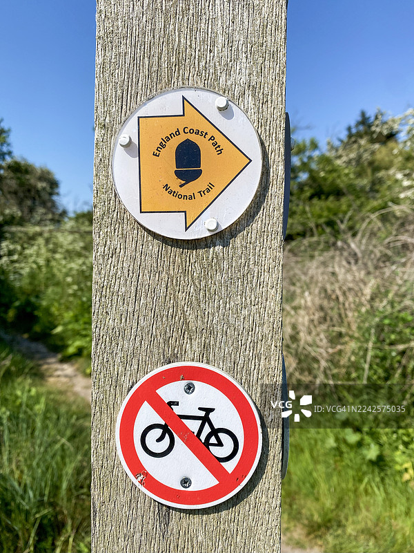 英格兰海岸小径标志和禁止骑行标志立于木柱上图片素材
