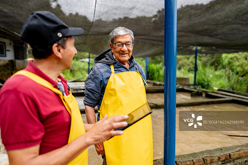 水产养殖场里的鳟鱼养殖户使用平板电脑技术图片素材