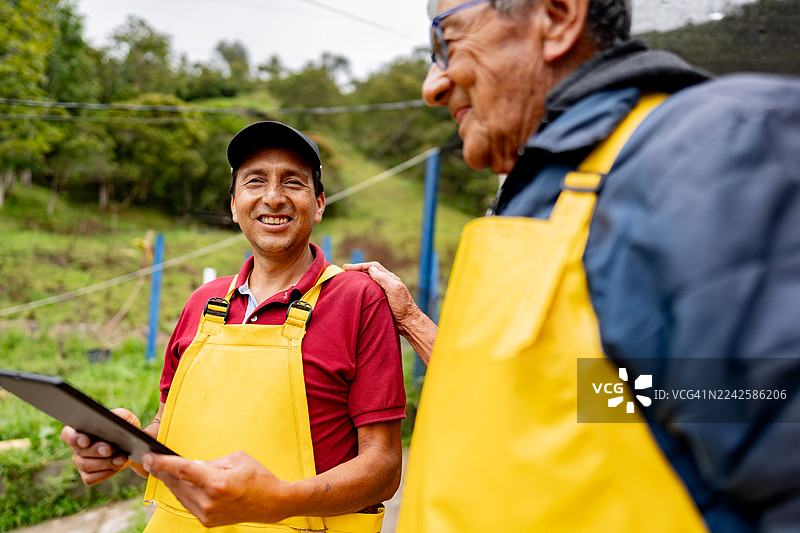 水产养殖场里的鳟鱼养殖户使用平板电脑技术图片素材