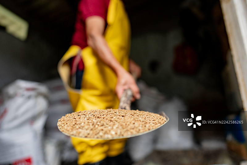 特写：一名渔场工人正在为鳟鱼养殖准备饲料图片素材