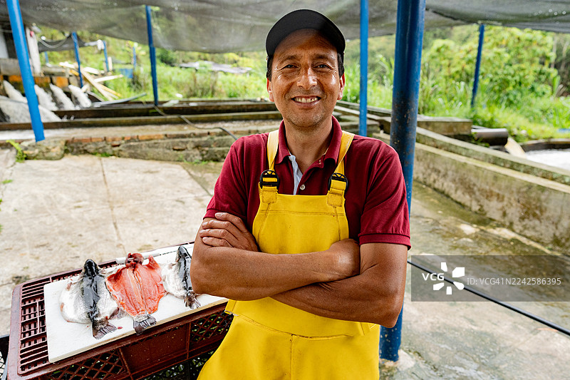 鳟鱼养殖场里一位鱼农的肖像图片素材