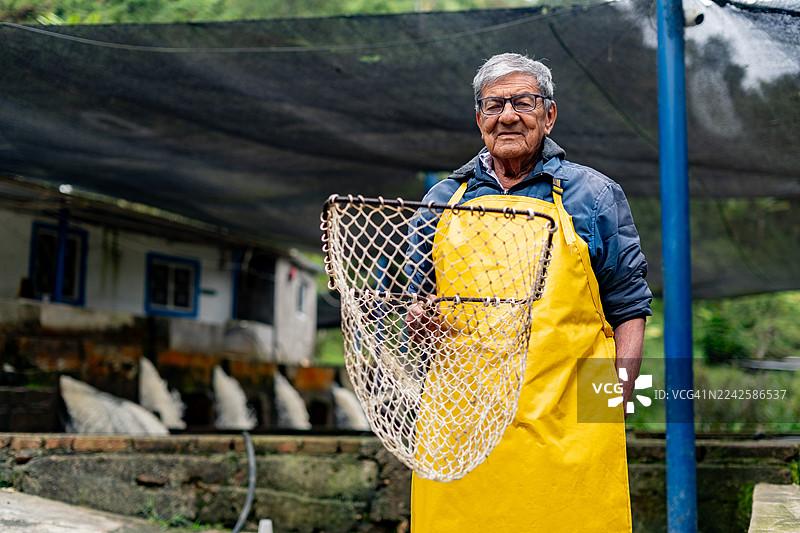 哥伦比亚桑坦德省皮耶德奎斯塔水产养殖场一位老年鳟鱼养殖户的肖像图片素材