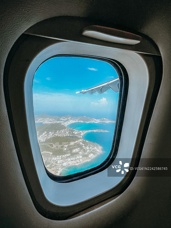 从飞机舷窗看到的海岸岛屿的鸟瞰图图片素材