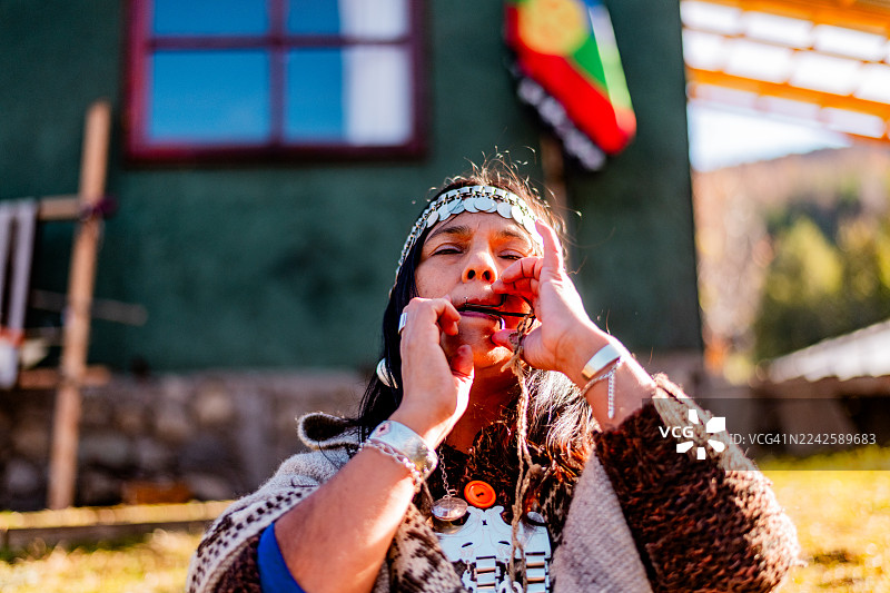 阿根廷圣马丁德洛斯安第斯地区一位成熟的马普切妇女正在演奏民族乐器图片素材