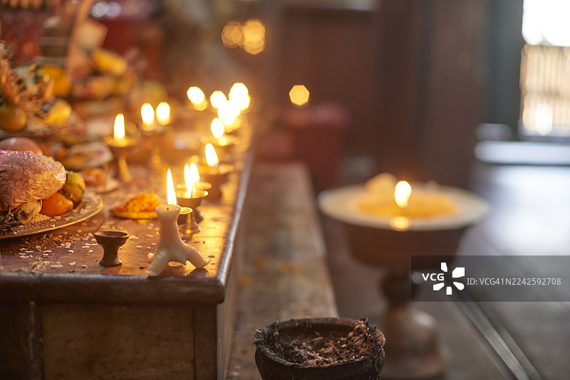 尼泊尔寺庙祭坛上点亮的黄油灯和供品图片素材