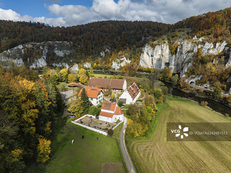 德国巴登-符腾堡州锡格马林根区蒂尔加滕附近,上多瑙河谷的凯佩勒庄园和圣乔治大教堂的空中视角,周围环绕着秋天的植被图片素材