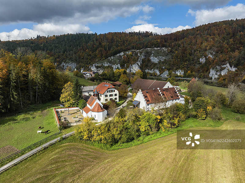 德国巴登-符腾堡州锡格马林根区蒂尔加滕附近的卡佩勒庄园和圣乔治大教堂的鸟瞰图,周围环绕着秋季植被图片素材