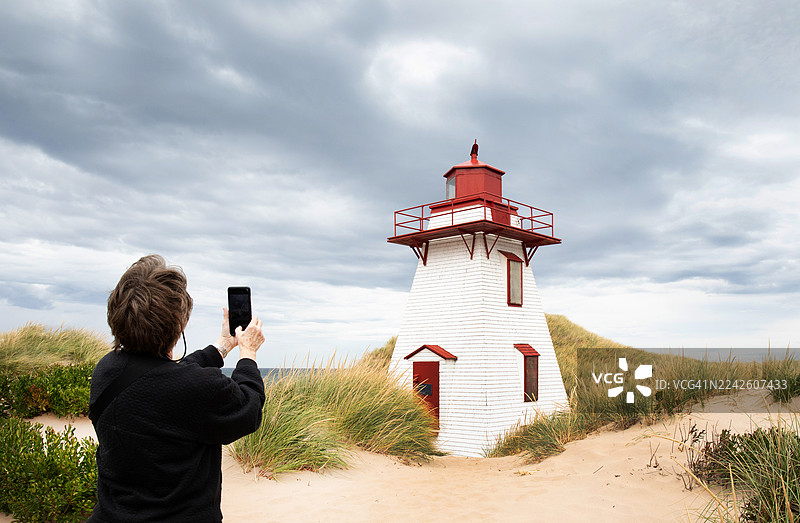 沙丘、灯塔和女游客图片素材