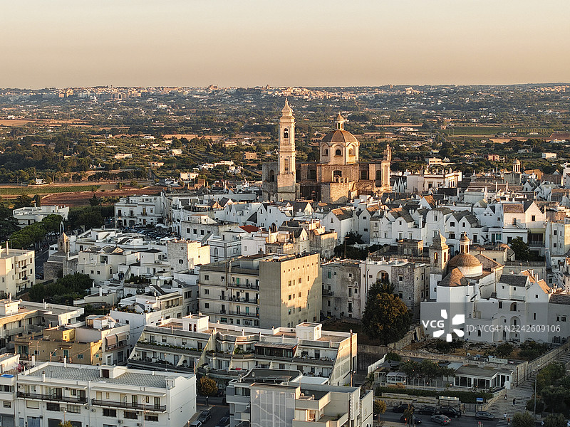普利亚大区洛科罗通多日落时分的鸟瞰图，有圆顶和粉刷成白色的建筑图片素材