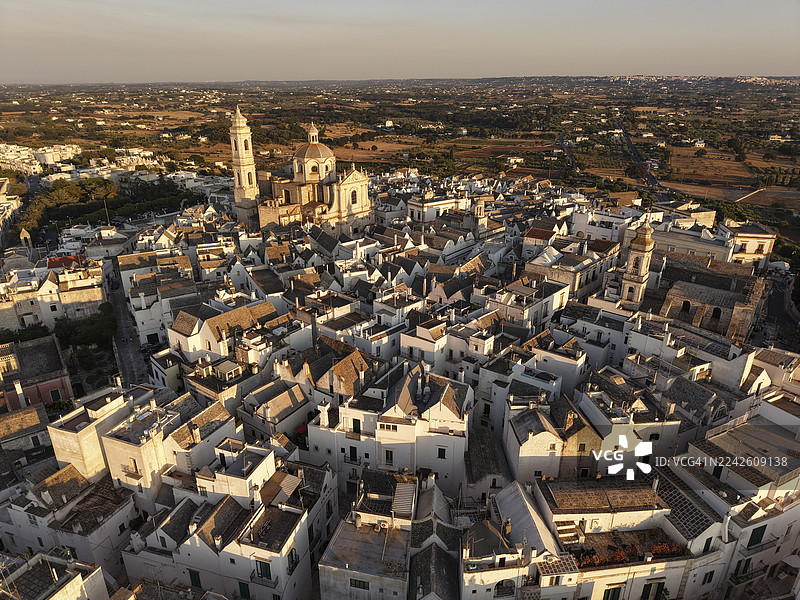 俯瞰夕阳下的洛科罗通多，欣赏其圆顶和粉刷成白色的建筑，位于意大利普利亚地区。图片素材