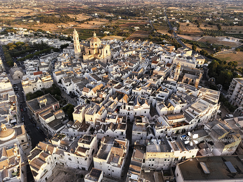 日落时分的洛科罗通多鸟瞰图，有圆顶和粉刷成白色的建筑，意大利普利亚。图片素材