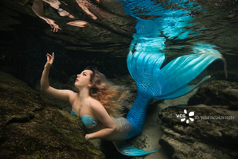 身着美人鱼服装的女子在水下游泳图片素材