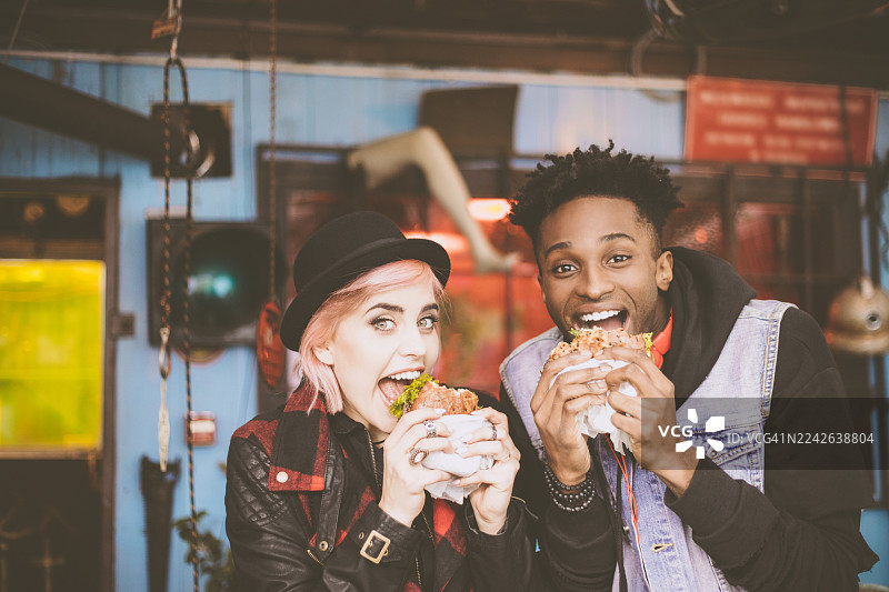 一位非裔美国男子与他的女性朋友一起吃汉堡图片素材