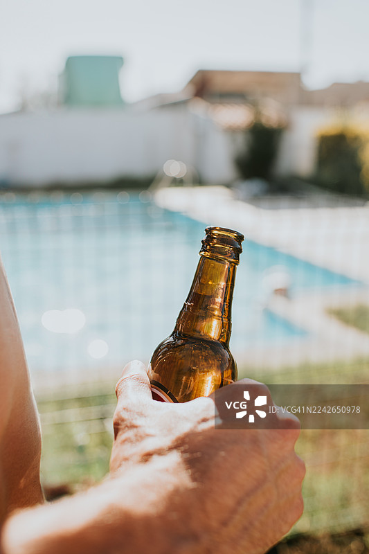 在泳池边悠闲的夏日时光，配上一杯冰啤酒图片素材