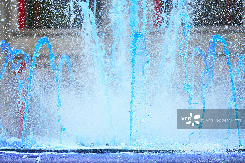 蓝色的喷泉水喷洒出清爽的水滴图片素材