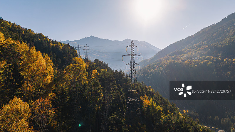 从高处/无人机视角拍摄的法国阿尔卑斯山脉中一排电力塔的景象图片素材