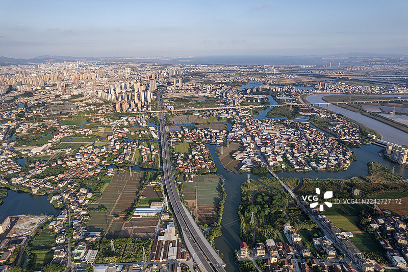 一条穿过平原上的田野和房屋的高速公路图片素材
