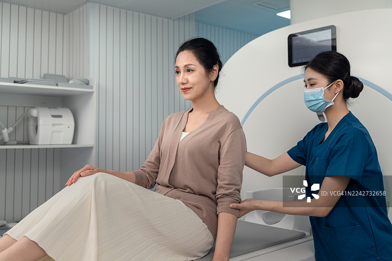 亚洲女护士在医院为年长女病患准备进行核磁共振成像扫描。图片素材