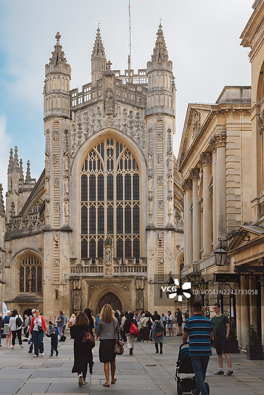 11世纪诺曼巴斯修道院的西景，游客和街头艺人在阳光明媚的日子里享受，历史建筑，户外娱乐，旅游目的地。图片素材