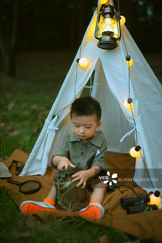 夜晚，亚裔小男孩在帐篷里玩耍图片素材