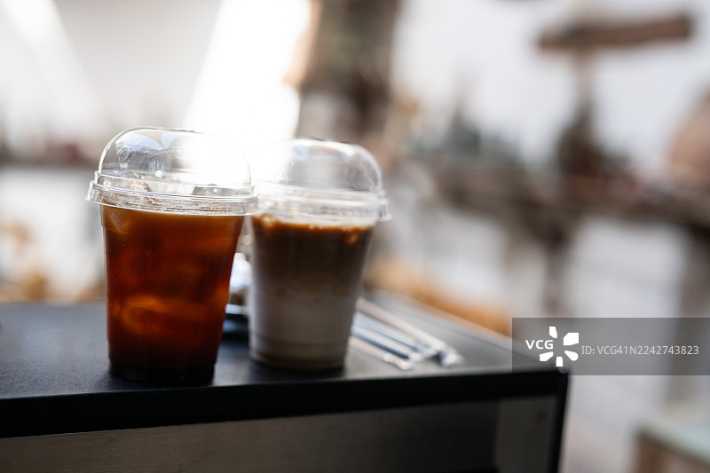 咖啡馆柜台上两杯冰咖啡的背景，具有选择性聚焦的特写，背景是模糊的历史街道图片素材