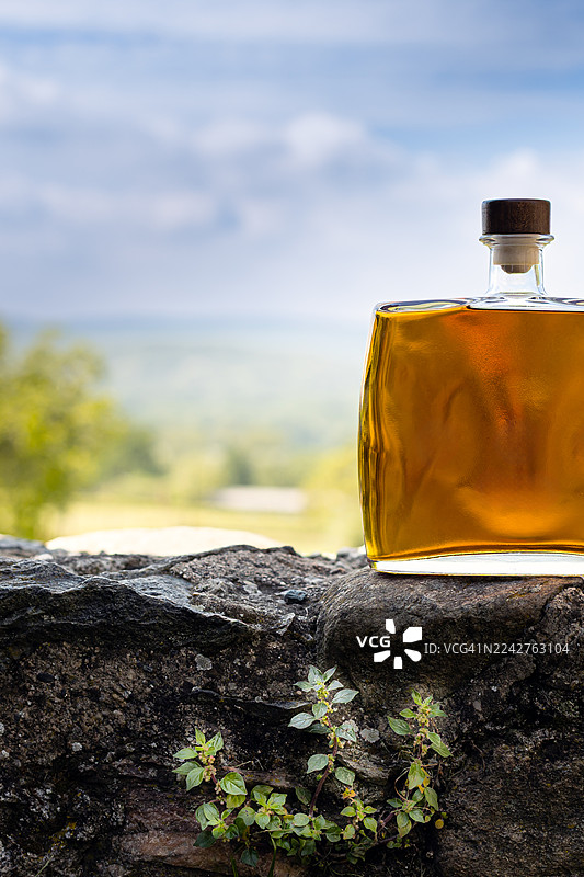 放置在户外的岩石上的格拉巴酒瓶图片素材