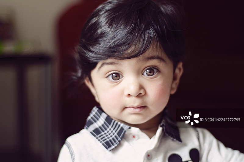 这是一个年轻印度男孩的特写肖像照。图片素材