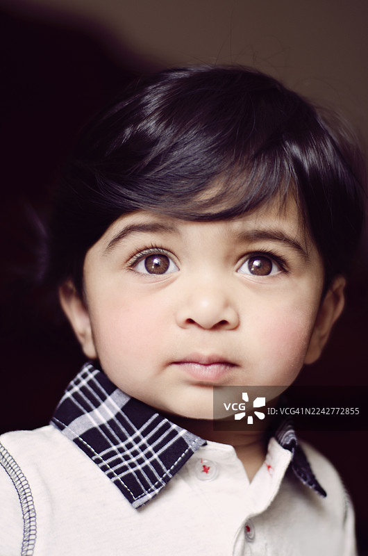这是一张年轻印度男童的特写肖像照片。图片素材