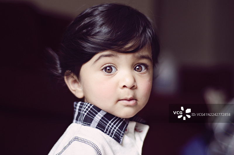 一位年幼的印度男孩的特写肖像照。图片素材