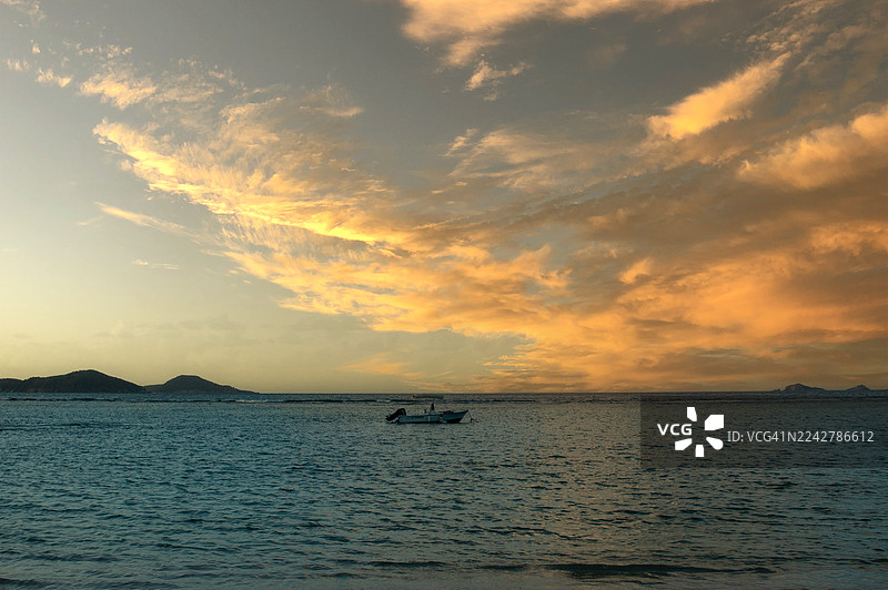 停泊在近海的船只与英属维尔京群岛壮丽的日落景色图片素材