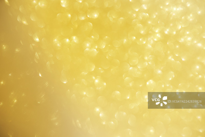 金色黄色的散景背景，带有柔和的光线和抽象的圆形点图片素材