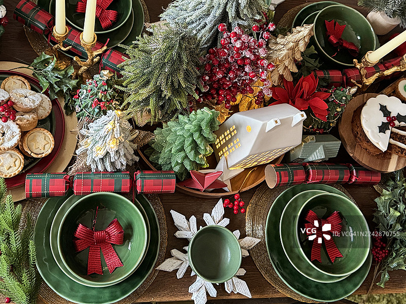 节日圣诞晚宴餐桌图片，配有椅子、蜡烛和圣诞树/节日用餐布置，季节性美食展示图片素材