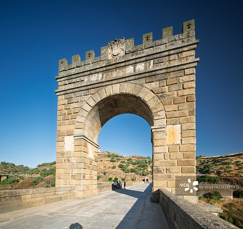 西班牙古老石头拱门通往托莱多历史古城，蓝天清晰，西班牙图片素材