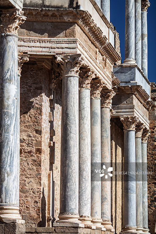 低角度拍摄的古罗马遗址，带有大理石柱，背景是晴朗的蓝天，展示了古典建筑和历史遗产，西班牙图片素材