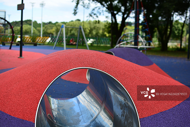 充满活力的红色和蓝色游乐场特写，带有隧道滑梯，充满趣味和活力图片素材