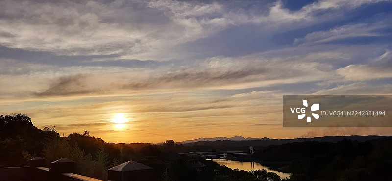 一条河流和远山的剪影风景之上壮丽的日落图片素材