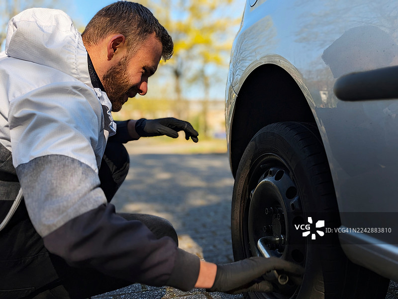 男子在路边修理汽车轮胎图片素材