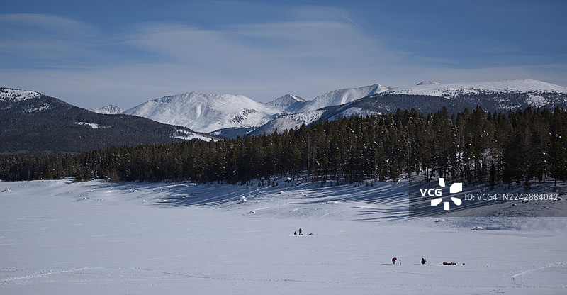 冬季风光，白雪皑皑的山峰、常绿森林和冰冻的湖泊，远处有人影，美国，利德维尔图片素材