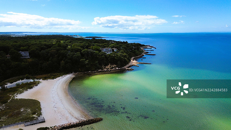 阳光明媚的日子里，从高处俯瞰隐蔽的海滩和郁郁葱葱的绿色海岸线，美国老银滩图片素材