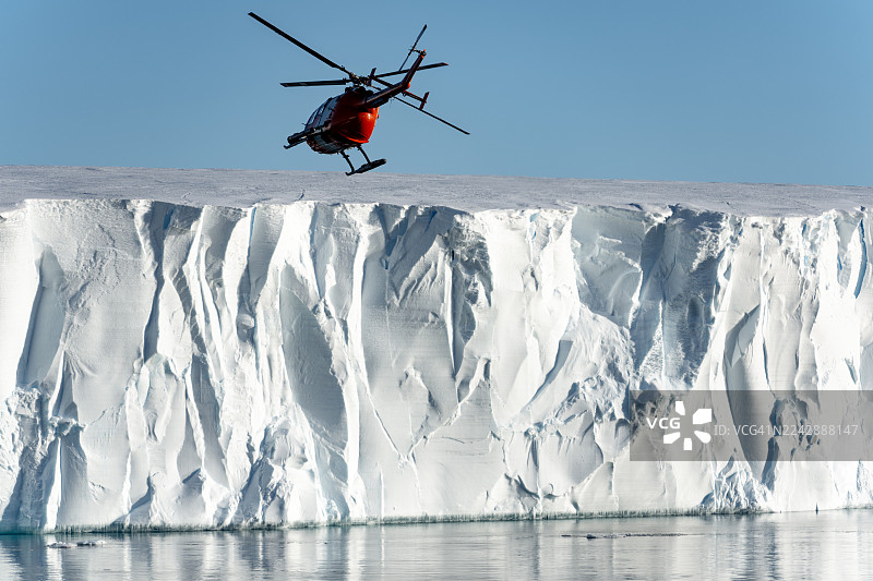 一架直升机正飞向位于威德尔海的一座巨大冰山。图片素材