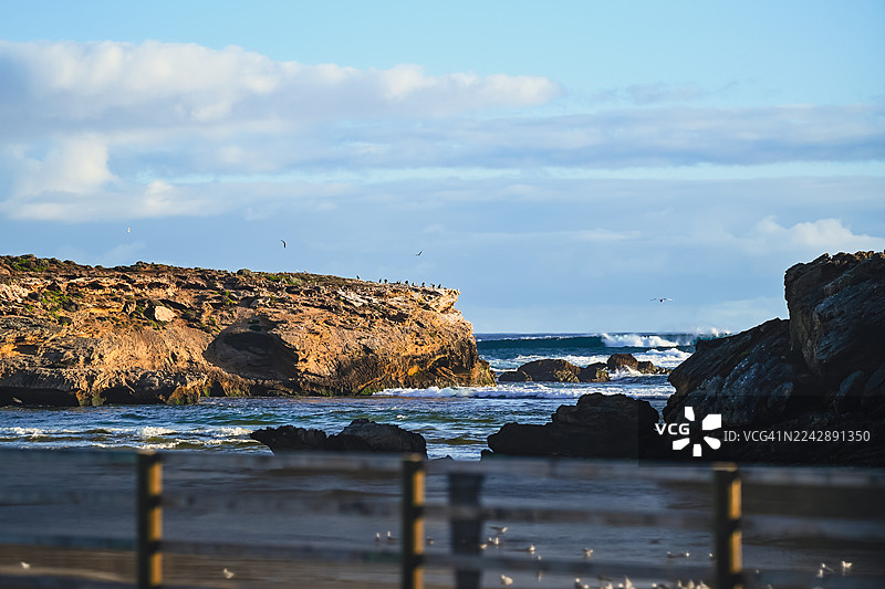 澳大利亚瓦南布尔崎岖海岸的风景，海浪拍打，天空多云图片素材
