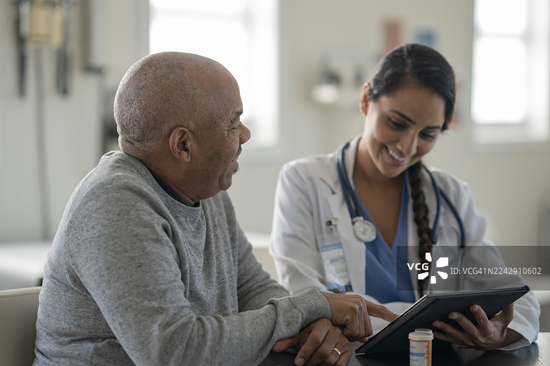 年长患者在诊所与富有同情心的女医生进行温馨的医疗咨询图片素材