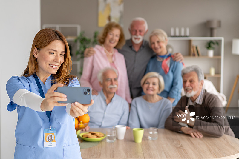 快乐的护士在放松的环境中与长者自拍图片素材