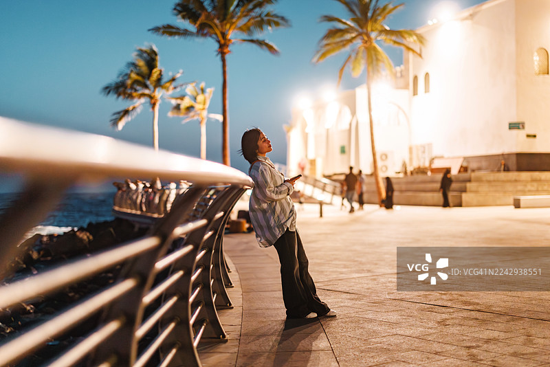 悠闲的亚洲游客在吉达清真寺附近享受傍晚时光图片素材