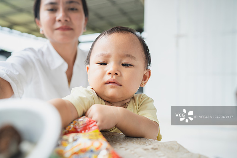 好奇的宝宝在妈妈的陪伴下探索物品图片素材