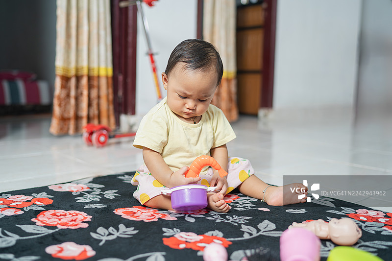 小女孩在室内独自玩玩具图片素材