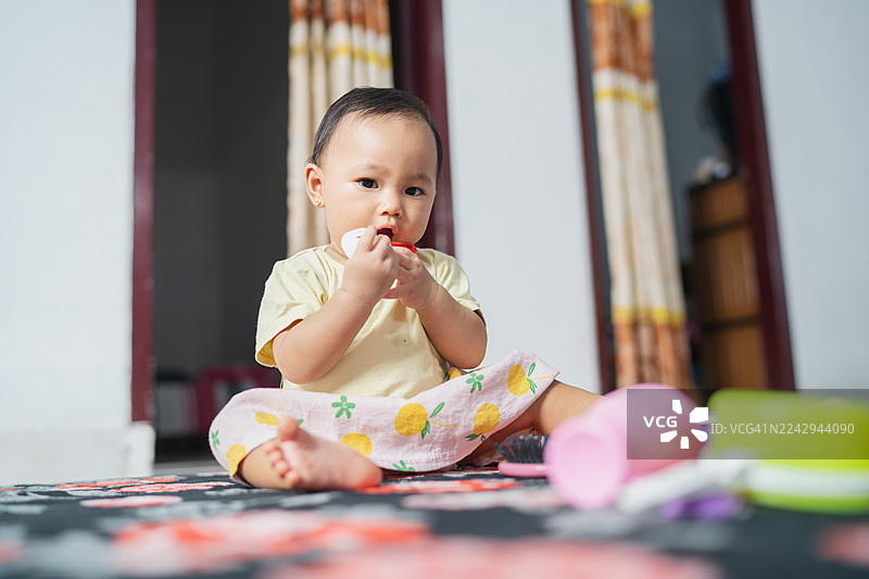 小女孩坐着，好奇地观察着玩具图片素材
