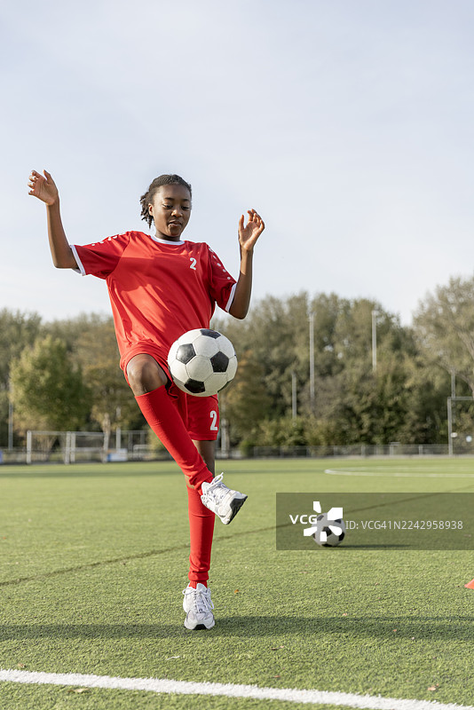 一位漂亮的黑人女孩在足球训练中跑步练习图片素材