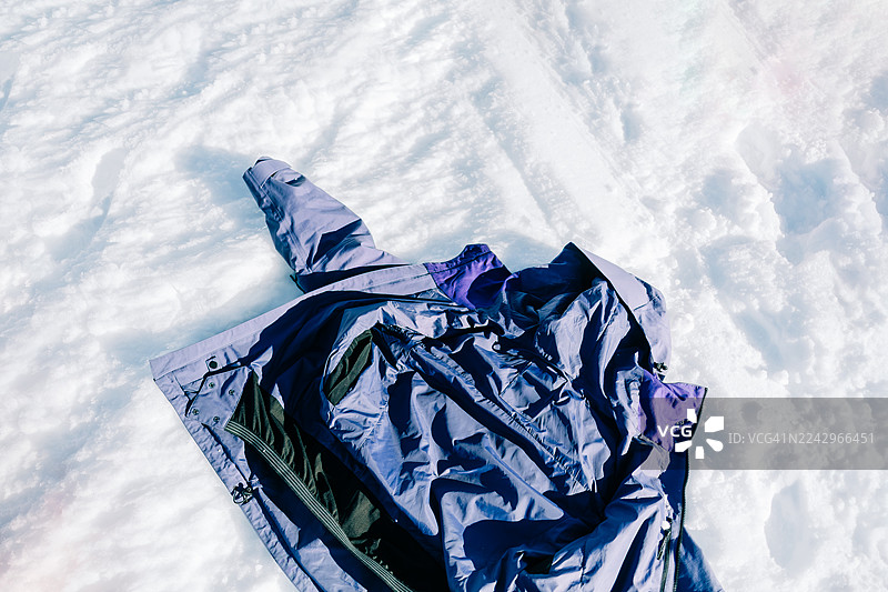 紫色的冬款夹克外套放在雪地上图片素材